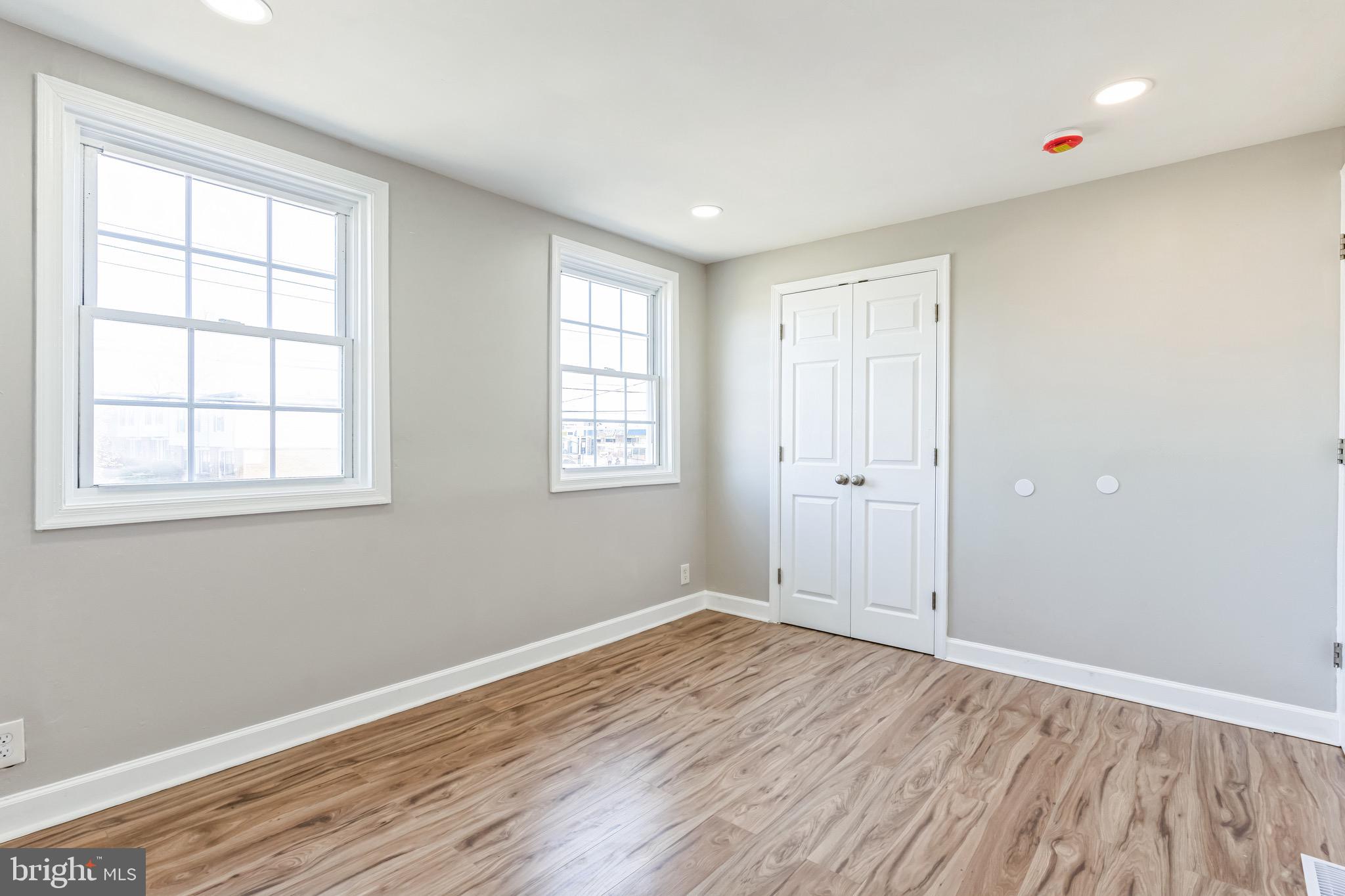 815 Fifth Avenue Baltimore, MD 21227 - Photo 11 of 17 an empty room with wooden floor and windows