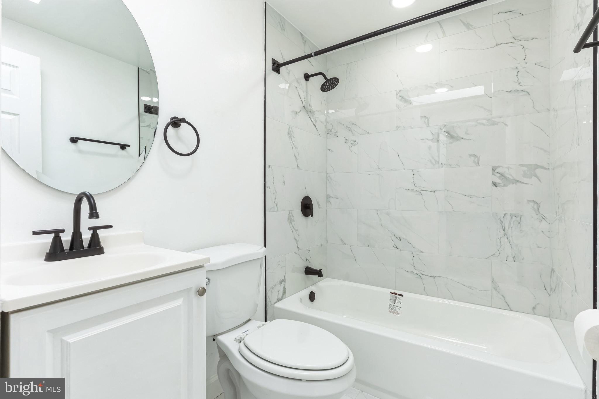 815 Fifth Avenue Baltimore, MD 21227 - Photo 12 of 17 a bathroom with a sink a toilet a mirror a bathtub and shower