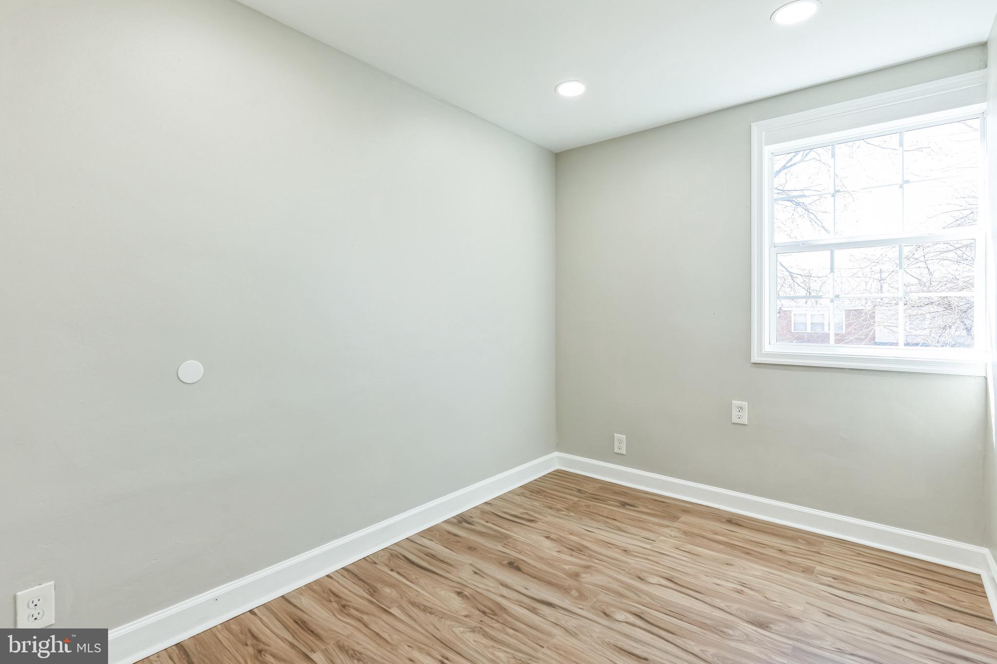 815 Fifth Avenue Baltimore, MD 21227 - Photo 14 of 17 an empty room with wooden floor and windows