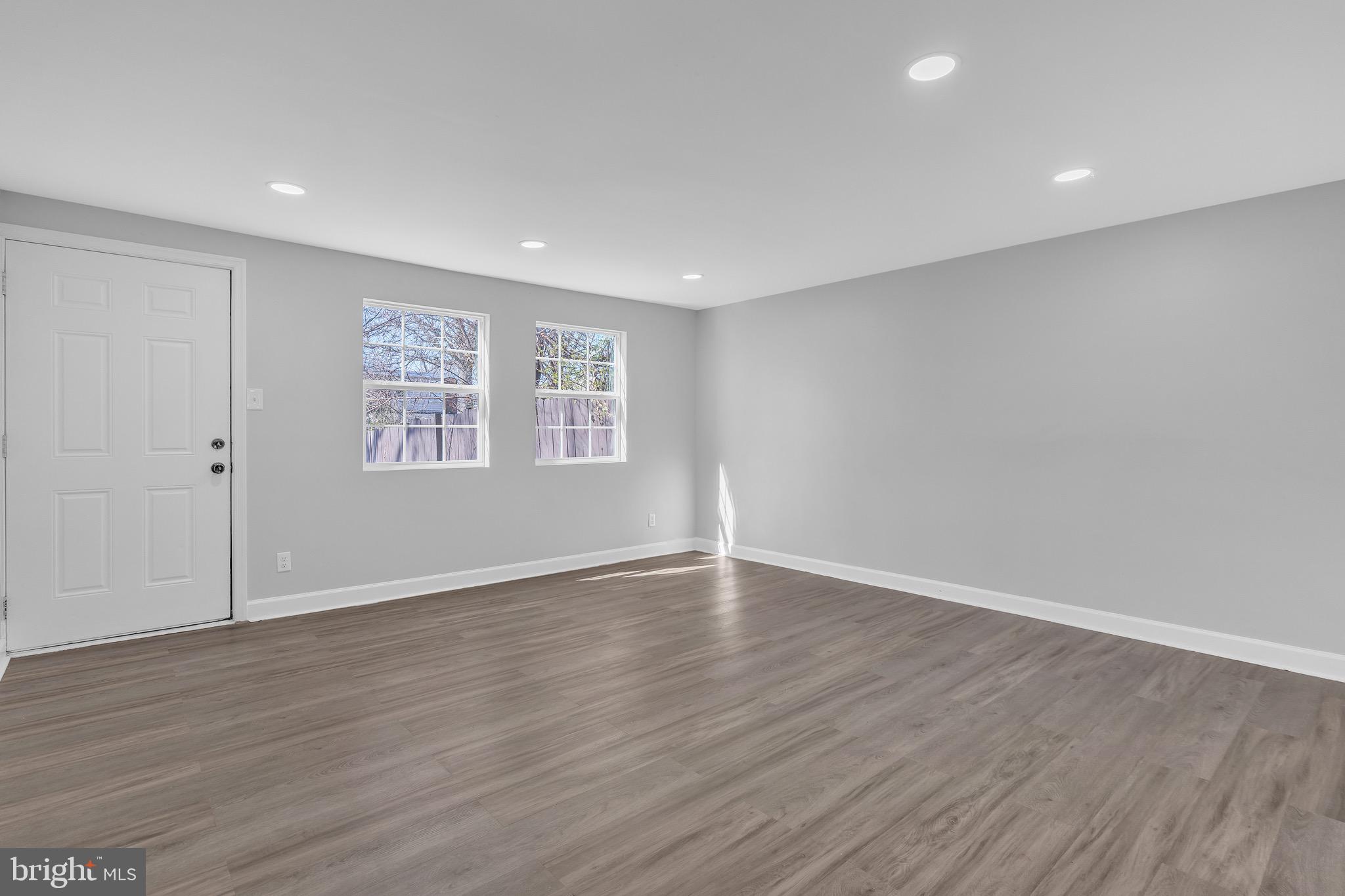 815 Fifth Avenue Baltimore, MD 21227 - Photo 5 of 17 a view of an empty room with wooden floor and a window