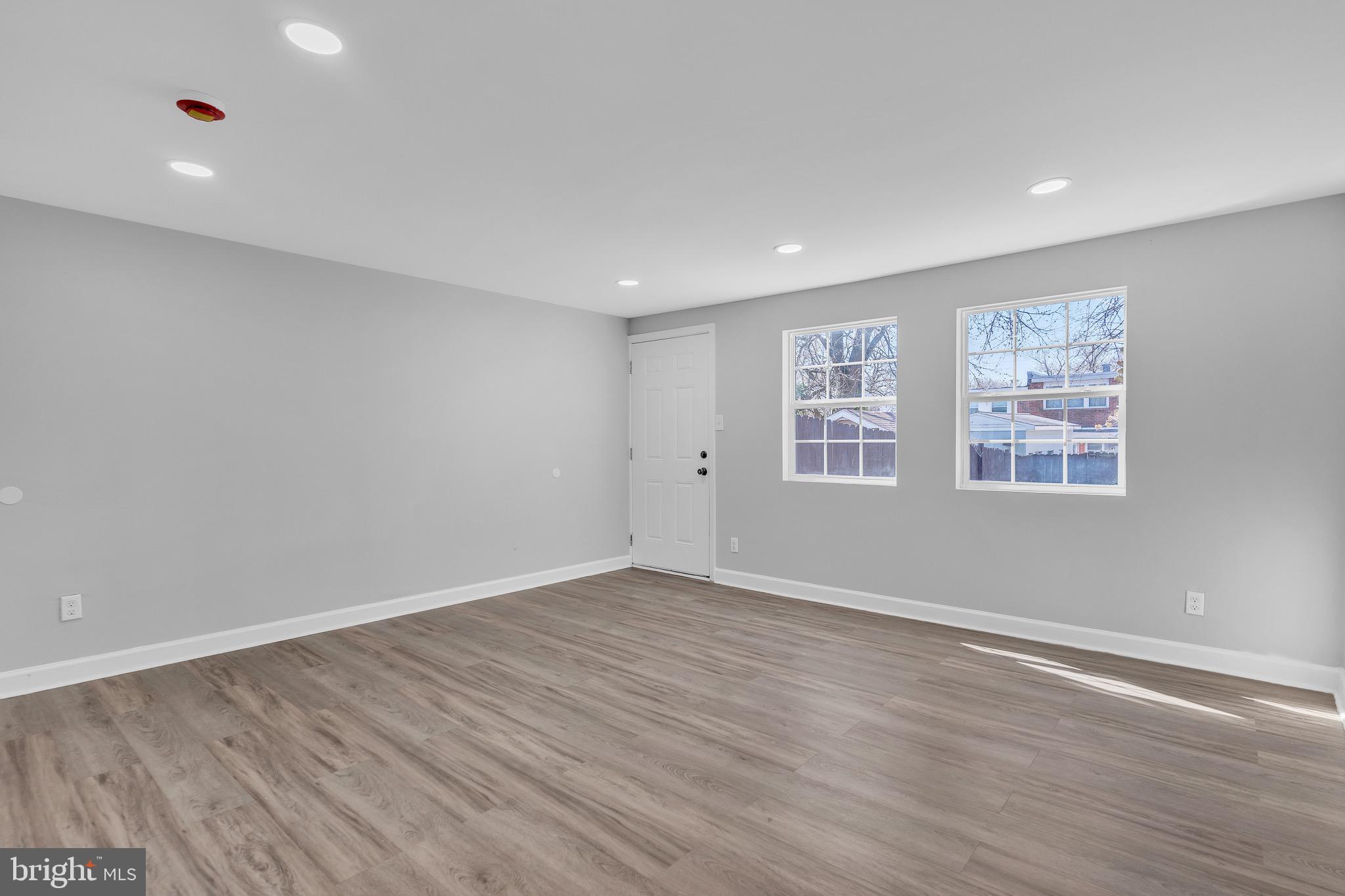 815 Fifth Avenue Baltimore, MD 21227 - Photo 7 of 17 a view of an empty room with wooden floor and windows