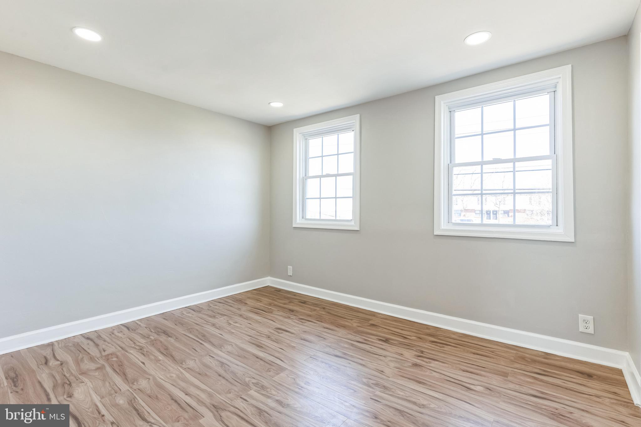 815 Fifth Avenue Baltimore, MD 21227 - Photo 10 of 17 an empty room with wooden floor and windows