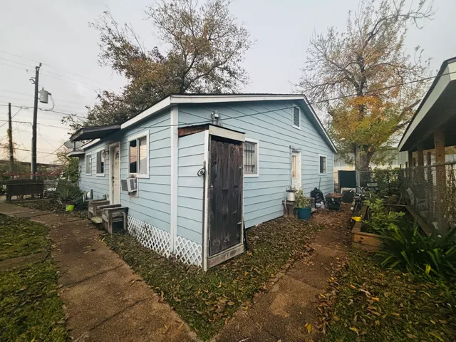 a view of a house with yard and a large tree