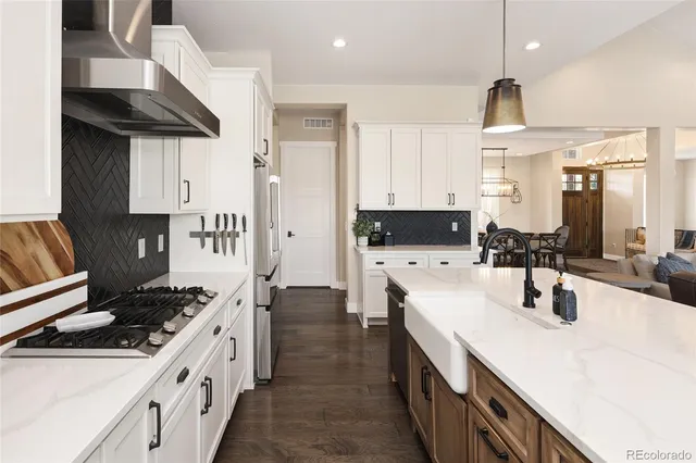 a kitchen with stainless steel appliances a sink stove and cabinets