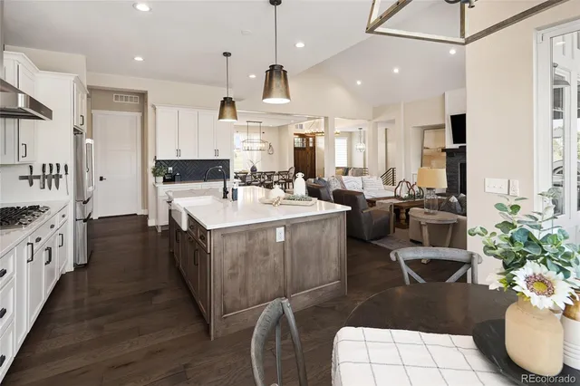 a large kitchen with kitchen island a large counter top space a sink stainless steel appliances and cabinets