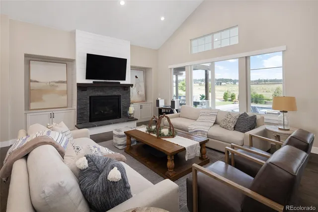 a living room with furniture a large window and a fireplace