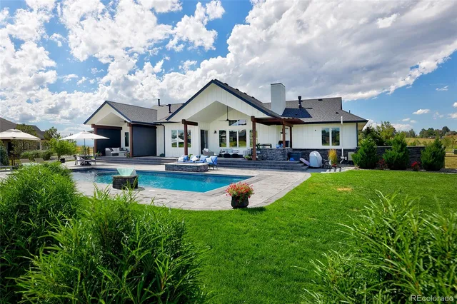 a swimming pool view with plants and large trees