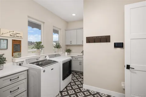 a kitchen with a sink a refrigerator and cabinets