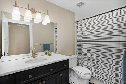 a bathroom with a double vanity sink mirror and toilet