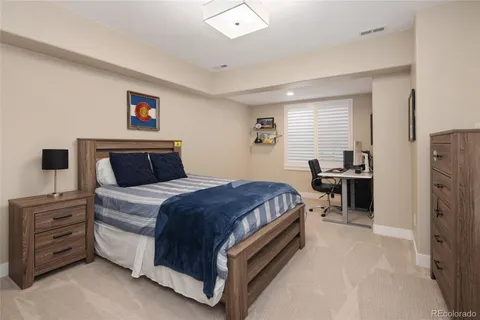 a bedroom with a bed and a refrigerator