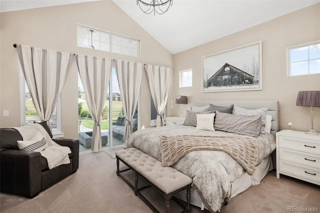 a bedroom with a bed couch and a large window