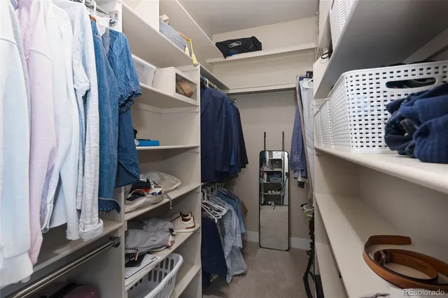a view of walk in closet with clothes and shoes