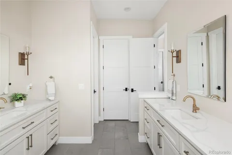 a spacious bathroom with double vanity a mirror a double vanity and a shower