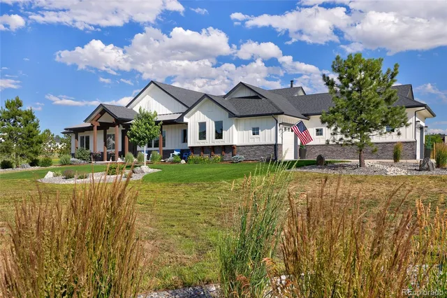 a view of a house with a big yard and large trees
