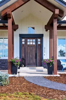 a view of a house with large windows and flower plants