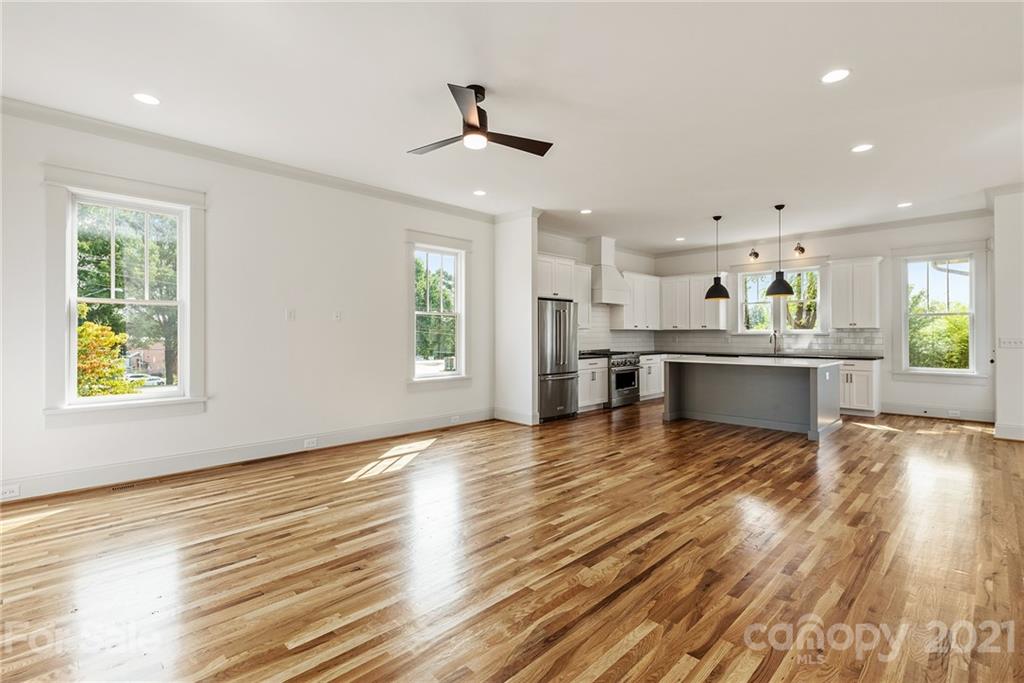 3807 Plainview Road Charlotte, NC 28208 - Photo 2 of 28 an empty room with wooden floor kitchen view and a window
