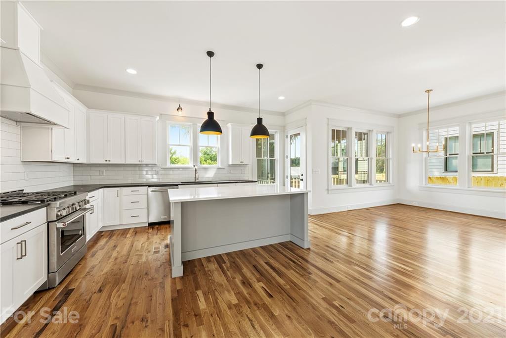 3807 Plainview Road Charlotte, NC 28208 - Photo 3 of 28 a kitchen with stainless steel appliances granite countertop wooden floors and view of living room