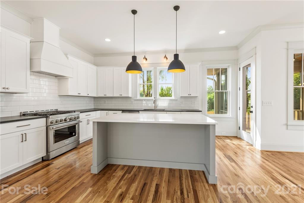 3807 Plainview Road Charlotte, NC 28208 - Photo 4 of 28 a kitchen with stainless steel appliances granite countertop a stove a sink and a wooden floors