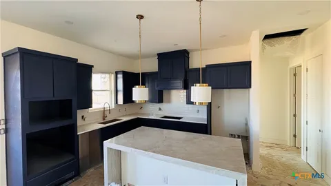 a kitchen with a sink a counter top space stainless steel appliances and cabinets