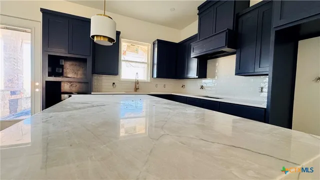 a view of a kitchen with a sink and a refrigerator