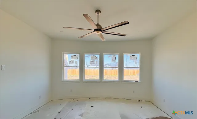 an empty room with a window and a fan