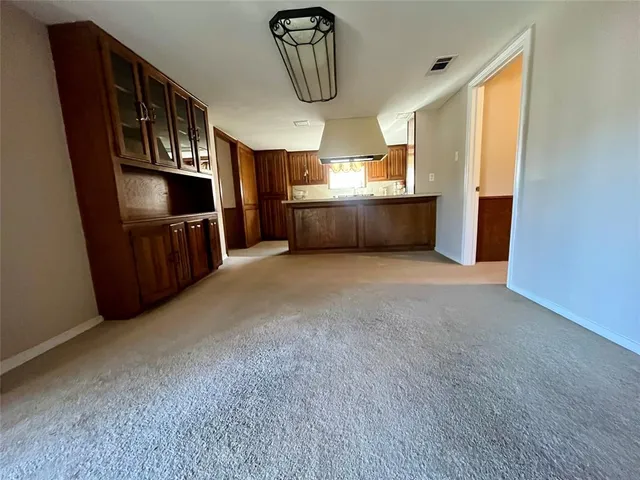 a view of an empty room with window and cabinet