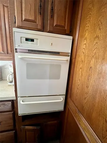 an empty room with windows and chandelier fan