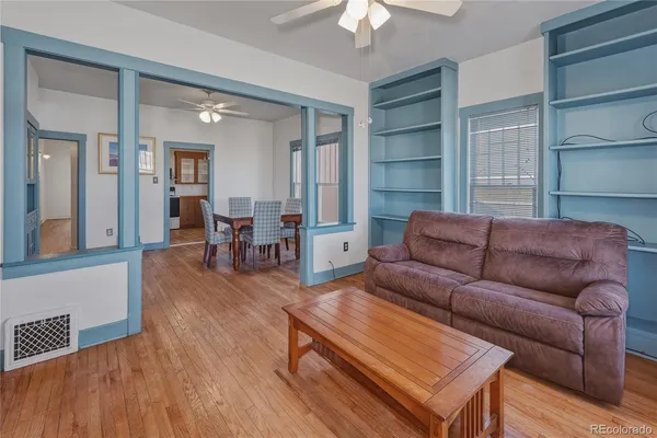 a living room with furniture and a wooden floor