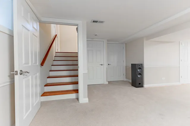 a view of an empty room with stairs and a window