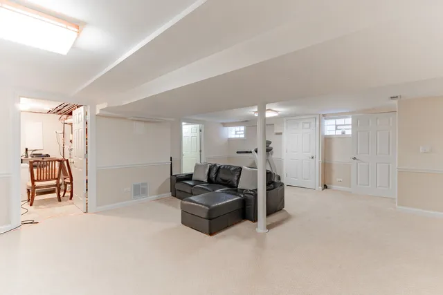 a living room with furniture a refrigerator and a sink