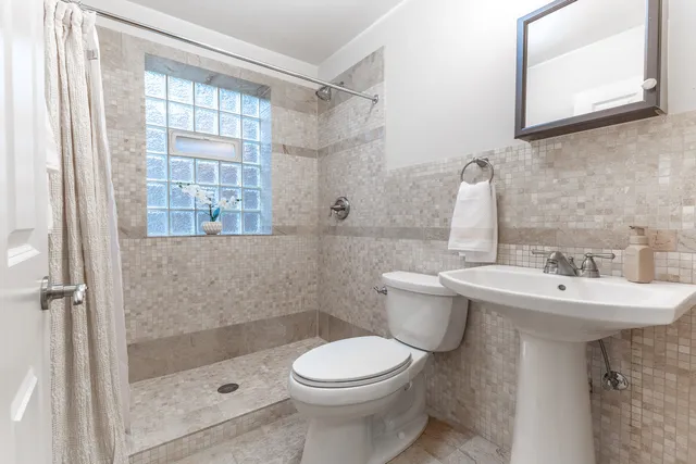 a bathroom with a sink toilet and shower
