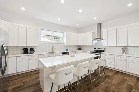 a en suite bathroom with a granite countertop sink and a mirror