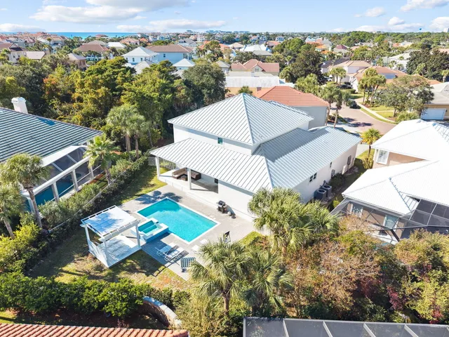 an aerial view of a city with lots of residential buildings ocean and mountain view in back