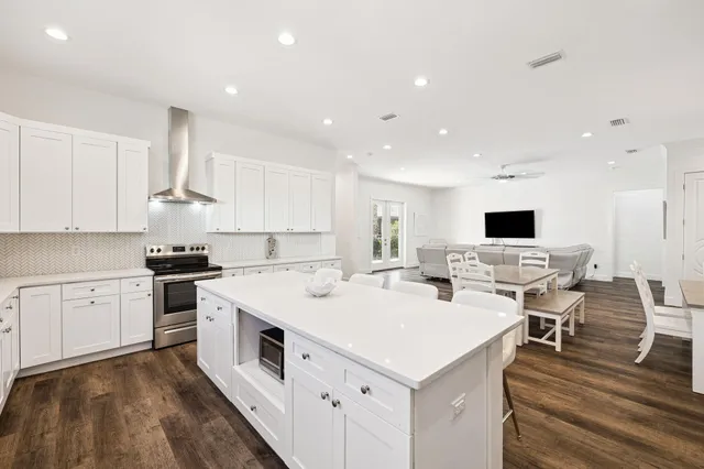 a view of a white house with a large windows and a palm tree