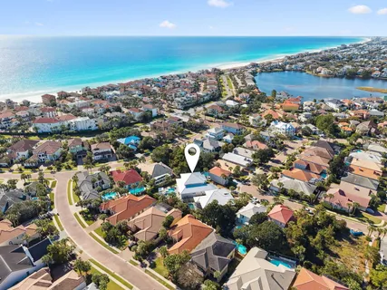 a large white kitchen with a stove a sink a refrigerator and white cabinets with wooden floor