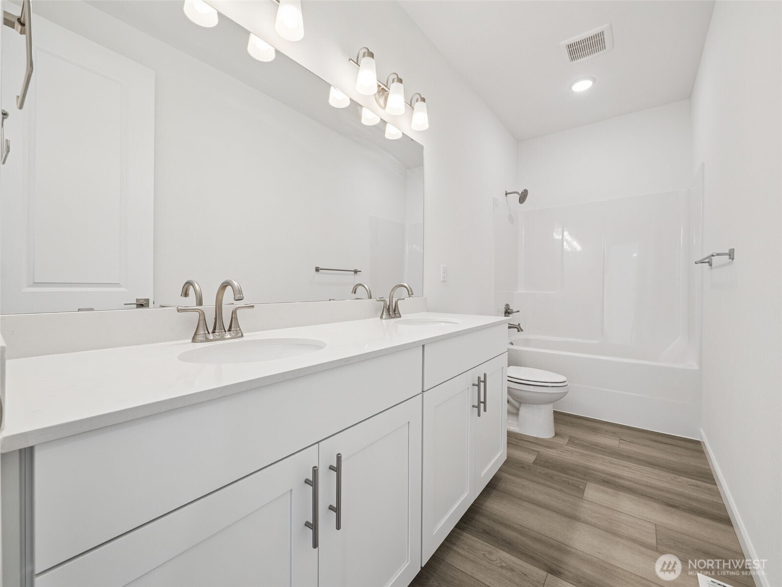 1132 Tanner Avenue, Unit 111 Buckley, WA 98321 - Photo 13 of 17 a spacious bathroom with a double vanity sink a toilet and a mirror