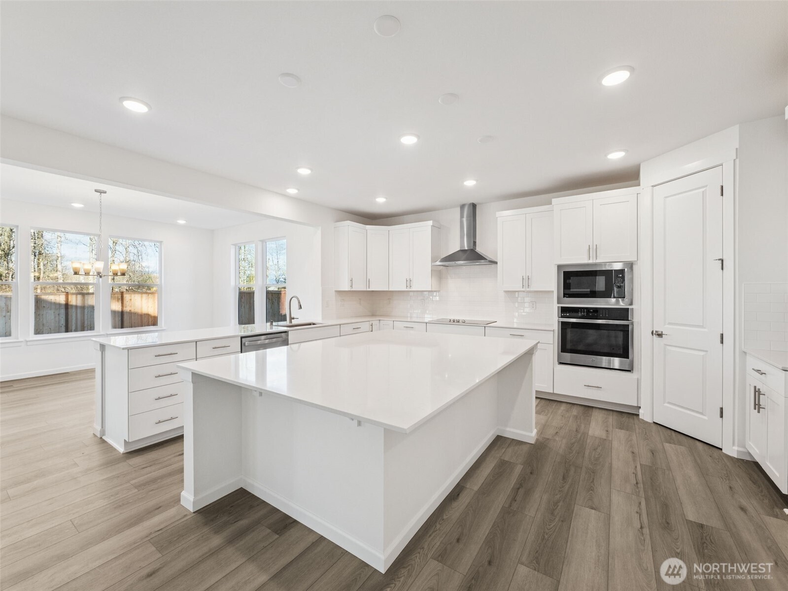 1132 Tanner Avenue, Unit 111 Buckley, WA 98321 - Photo 5 of 17 a large white kitchen with kitchen island a large counter top and appliances