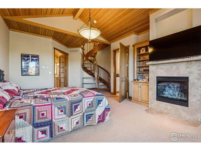 a bedroom with a bed a flat screen tv and a fireplace