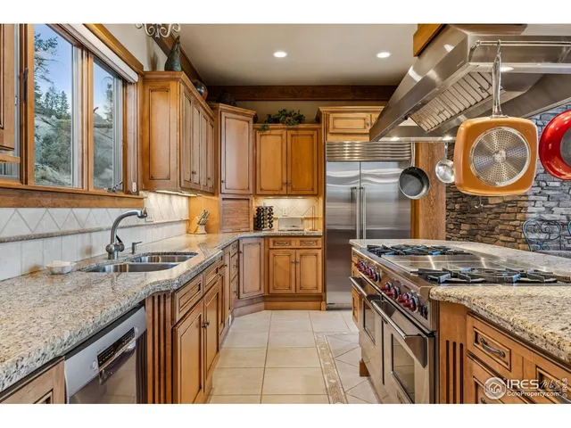 a kitchen with granite countertop a sink stove and cabinets