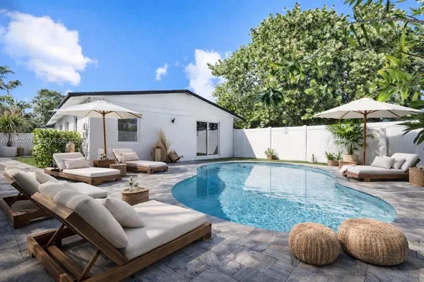 a view of a house with backyard and sitting area