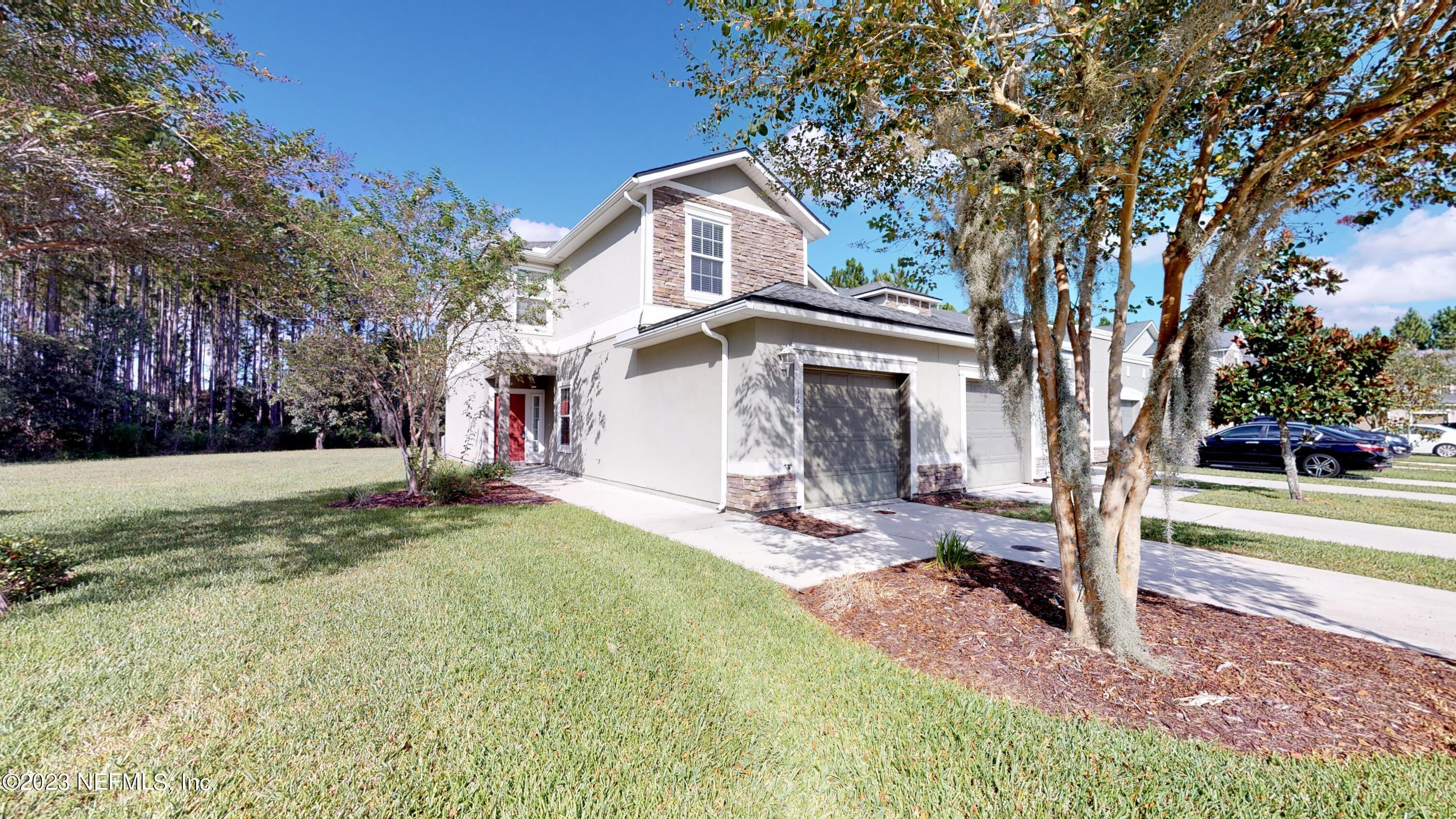 a view of a house with backyard and trees