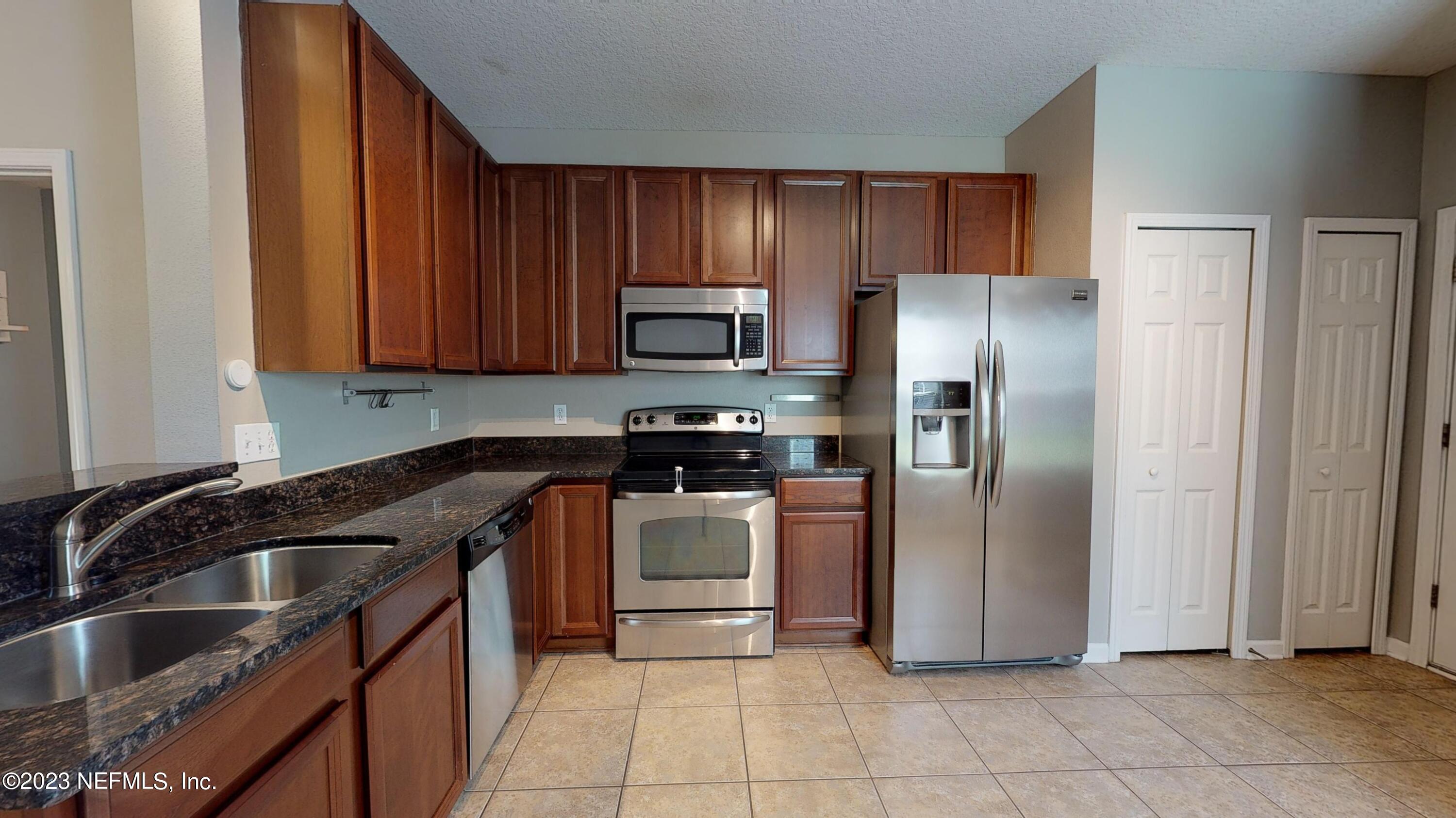 168 Leese Drive St. Johns, FL 32259 - Photo 4 of 25 a kitchen with granite countertop a refrigerator and a sink