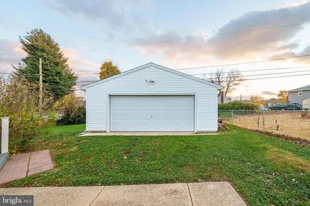 a brick house next to a yard with big trees