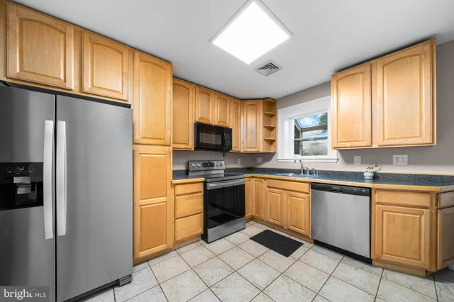 a kitchen with granite countertop stainless steel appliances a refrigerator sink and microwave