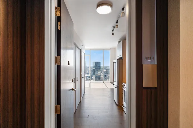 a view of a hallway with a chandelier and a bathroom