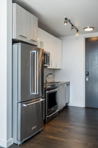 a kitchen with stainless steel appliances granite countertop a refrigerator and a stove top oven