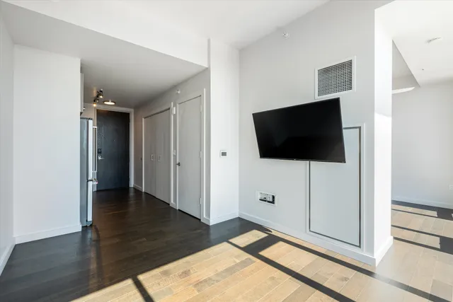a view of a livingroom with wooden floor and flat screen tv