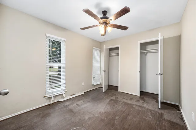 an empty room with closet and windows