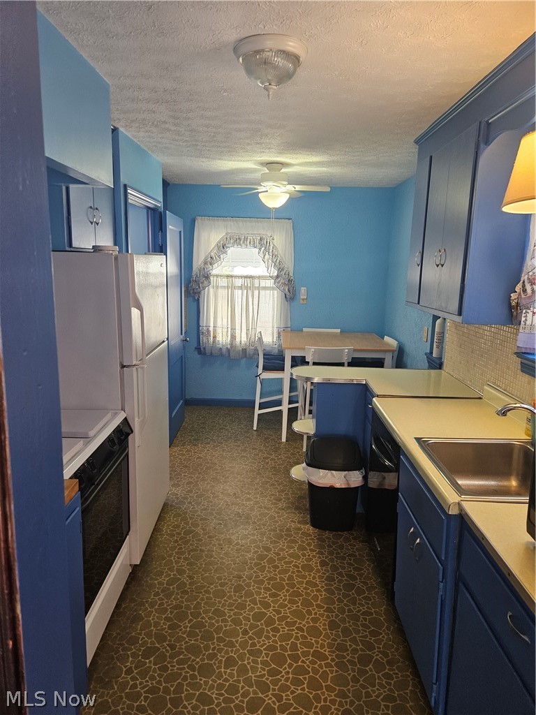 4516 Fulton Road Cleveland, OH 44144 - Photo 5 of 17 Kitchen with decorative backsplash, range, ceiling fan, and blue cabinets