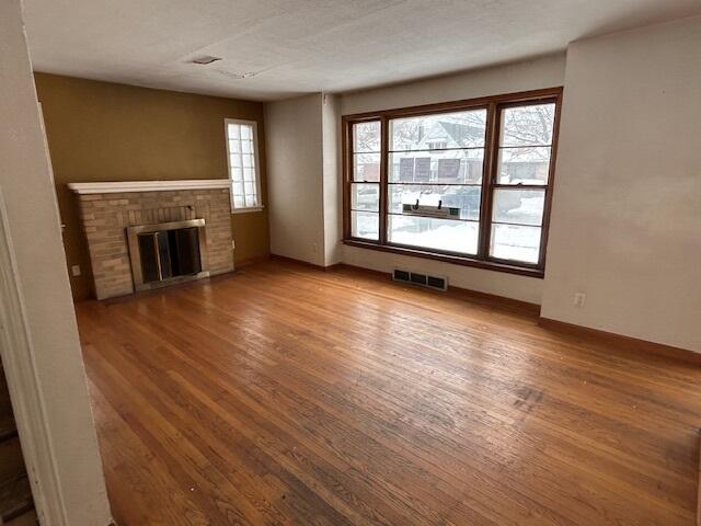 17946 Roy Street Lansing, IL 60438 - Photo 5 of 17 an empty room with wooden floor fireplace and windows